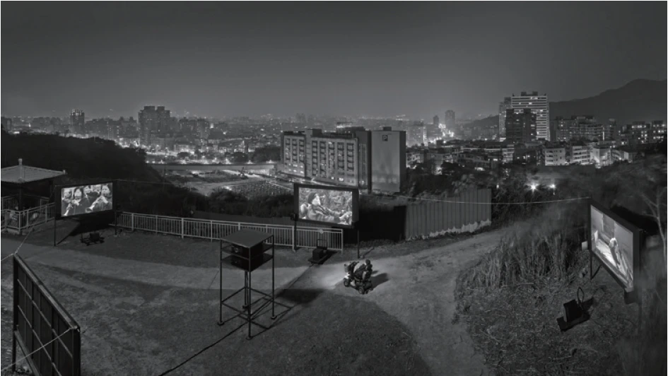 圖7 《殘響世界回樂生》：設置四座巨大銀幕放映四段影片，影片的背景正是黑暗中隱隱可見的台北市夜景與捷運工地。-圖片