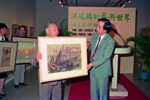 點擊觀看大圖-北美館於1987年9-11月舉辦「洪瑞麟的藝術世界──礦工與裸女」,洪瑞麟捐贈12件作品予本館,由黃光男館長代表接受;洪瑞麟手上持著《帆船》(1930),後面作品左起《三礦工》(1954)、《夕日》(1982)即為當時捐贈本館作品。 北美館於1987年9-11月舉辦「洪瑞麟的藝術世界──礦工與裸女」,洪瑞麟捐贈12件作品予本館,由黃光男館長代表接受;洪瑞麟手上持著《帆船》(1930),後面作品左起《三礦工》(1954)、《夕日》(1982)即為當時捐贈本館作品。-圖片