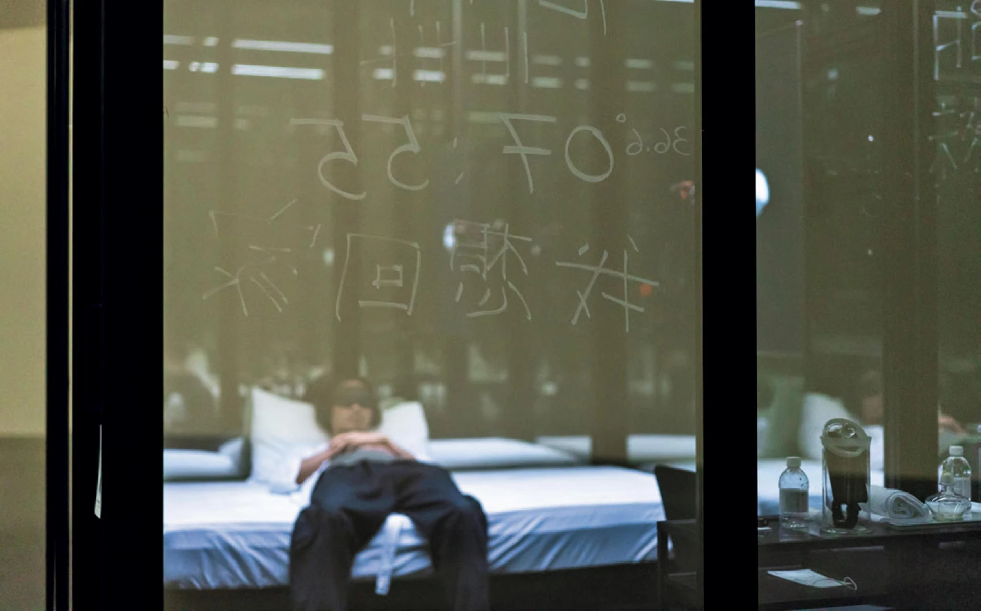 Baboo，《新！王冠度假村》，2020；隔離於度假村內的觀眾只能看見自已的鏡像及隱約的外部剪影。三個小時的隔離過程中，隨著耳機中聲音的建議／指示跳起體操、倒臥冥思、休閒娛樂，再或於牆上記錄、思考及自我釐清狀況；展場一景。©簡子鑫攝影-圖片