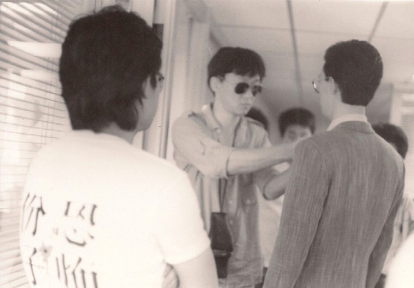 楊德昌為演員金士傑整裝，穿「恐怖份子」T 恤者為助導施名揚，1989；鴻鴻提供-圖片
