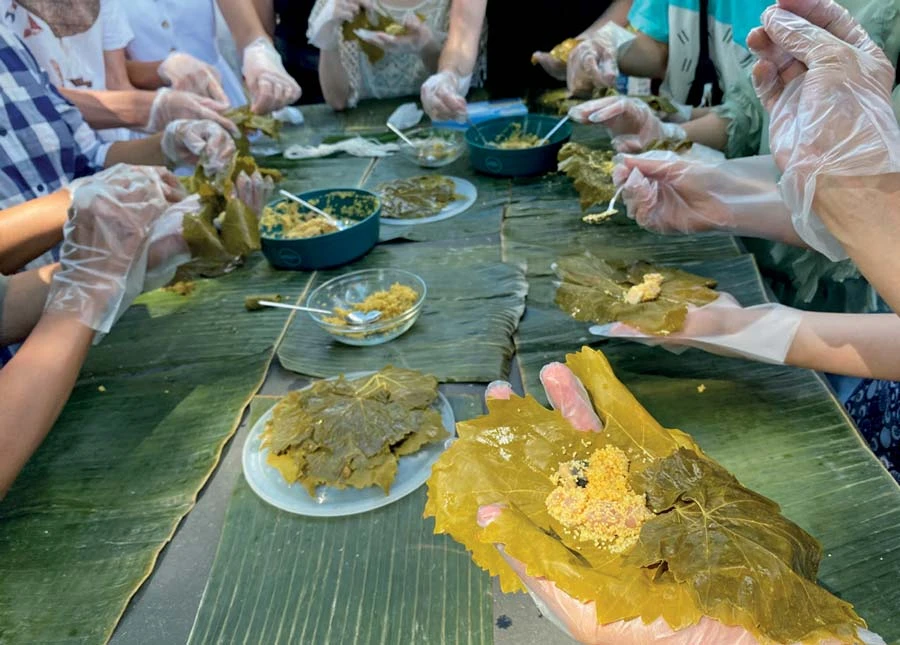 在卡塞爾舉辦的cinavu（吉拿富）食物工作坊，大家一同使用越南超市的香蘭葉作為外葉、土耳其超市的葡萄葉作為內葉，包裹著台灣來的小米、亞洲超市的冷凍A.C.蝸牛，以及德國超市的豬五花肉-圖片