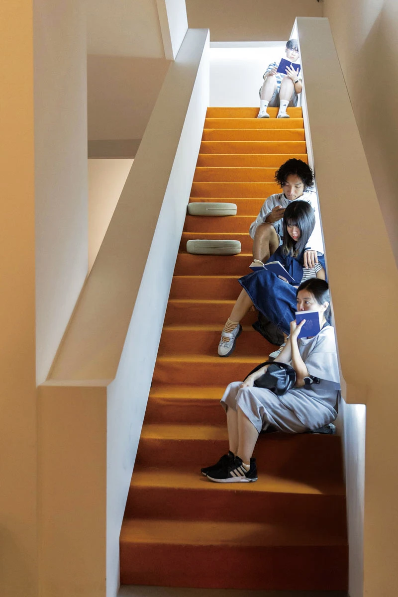 點擊觀看大圖-「書房計畫」將平時鮮少使用的樓梯空間改造為閱覽飛地,邀請民眾攜帶小說至梯間,享受一段靜謐的閱讀時光 「書房計畫」將平時鮮少使用的樓梯空間改造為閱覽飛地,邀請民眾攜帶小說至梯間,享受一段靜謐的閱讀時光-圖片