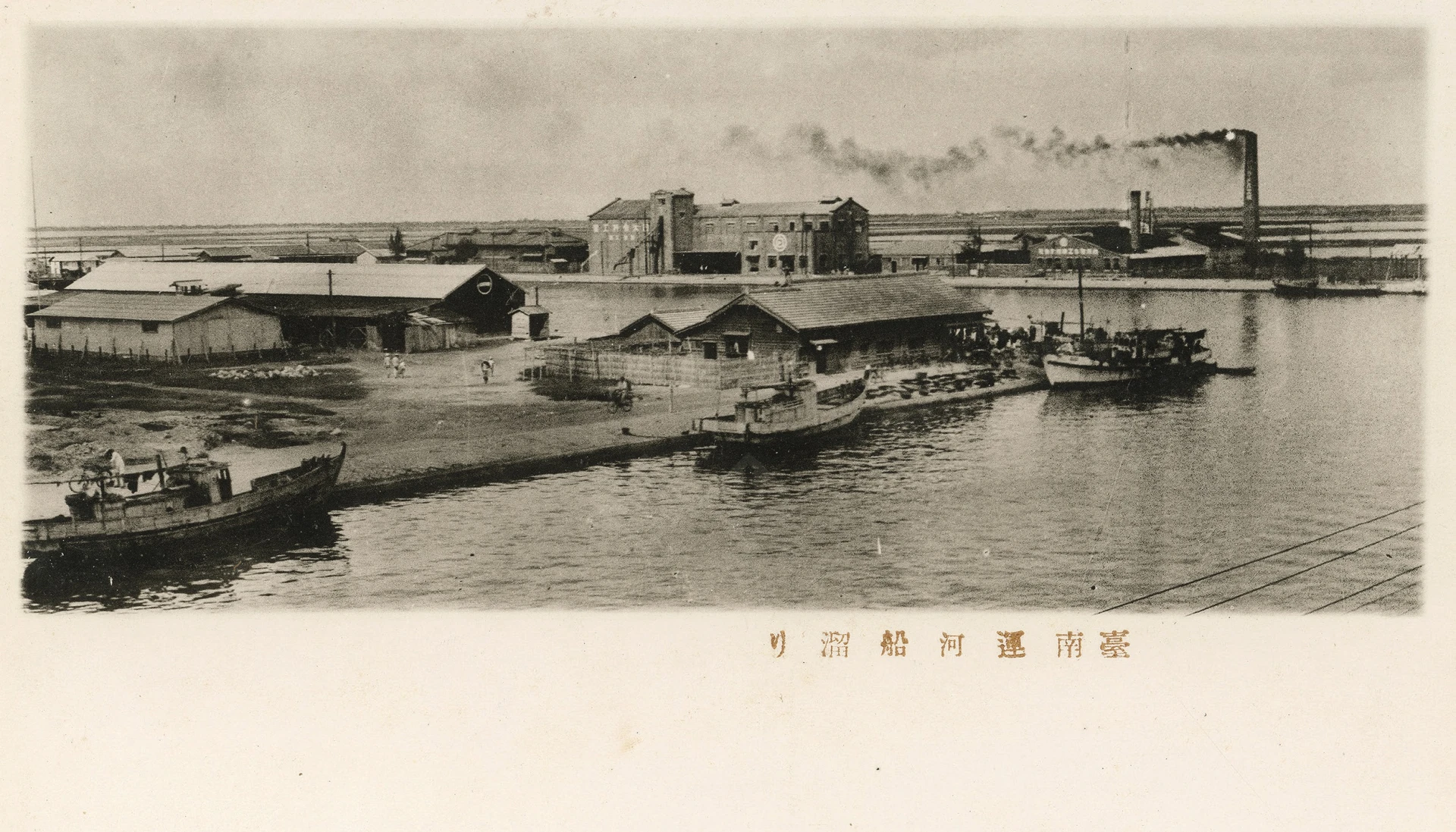 臺南運河碼頭老照片。遠處兩棟大型建築物分別是：（左）大日本製冰株式會社臺南第二工場（右）臺灣糖化工業株式會社。圖片來源：臺南市政府觀光旅遊局-圖片