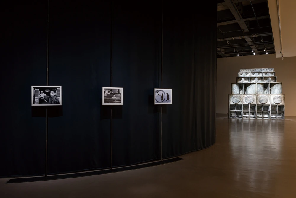 圖右側為納里．沃德（Nari Ward），《音聲系統》（<i>SOUND SYSTEM</i>），2025，大理石，337.5×82×338公分，藝術家及 Territorio，GALLERIA CONTINUA，Lehmann Maupin版權所有 © Nari Ward Studio。2025台北雙年展現場；呂國瑋攝影。-圖片