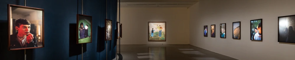 圖片中間為陳進，《野邊》，1934，膠彩、絹，186×171公分，臺北市立美術館典藏。圖片左側及右側分別為托比亞斯．茲耶羅尼（Tobias Zielony），《黃金（里加）》（<i>Golden in Riga</i>），2018；《偽裝（基輔）》（<i>Maskirovka in Kyiv</i>），2017。2025台北雙年展現場；呂國瑋攝影。-圖片