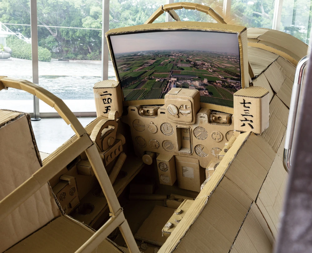 邱子晏，《偽飛行場》，2025，零式戰鬥機複製品搭配顯示器、影片、碉堡造型之音聲座椅，15分鐘，1200×900×300公分，120×45 ×40公分，藝術家版權所有，由 2025 台北雙年展委託製作。2025台北雙年展現場；呂國瑋攝影。-圖片