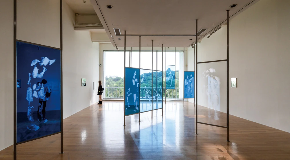 莊偉（Isaac Chong Wai），《觸動：英雄本色》（<i>Touched: A Better Tomorrow</i>），蝕刻玻璃、壓克力與鏡，每幅160×70公分，藝術家及 Blindspot Gallery, Hong Kong 和 Zilberman, Istanbul/Berlin 版權所有，由 2025 台北雙年展委託製作。2025台北雙年展現場；呂國瑋攝影。-圖片