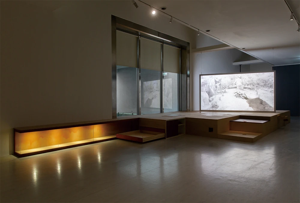 何彥諺，《私人旅行》，2025，單頻道錄像、黏土、木材、石膏、金屬、玻璃、石板、紙、樹脂、膠、燈光裝置，尺寸依空間而定，藝術家版權所有，由 2025台北雙年展委託製作。2025台北雙年展現場。-圖片