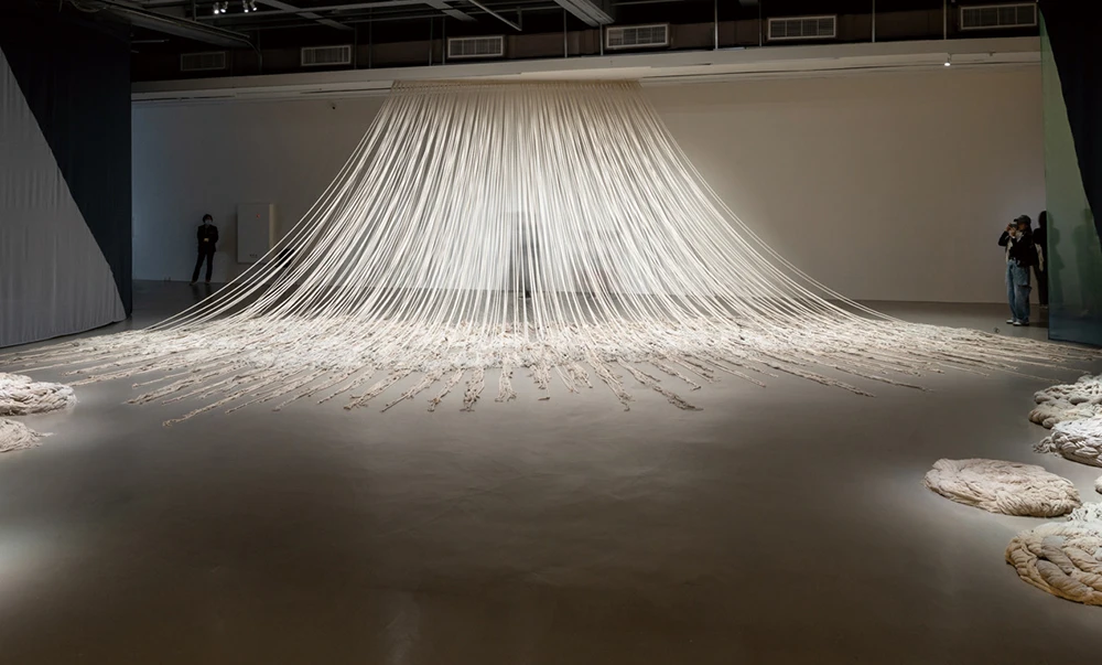 阿夫拉．阿達希里（Afra Al Dhaheri），《加重停頓》（<i>Weighted PAUSE</i>），2025，多種棉繩、木條、金屬掛鉤，400×450（牆面）×1200（地面）×900公分，藝術家版權所有。 2025台北雙年展現場；呂國瑋攝影-圖片