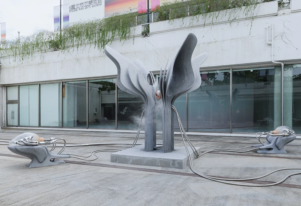 伊凡娜．巴希奇（Ivana Bašić） ，《靈變》（<i>Metanoia</i>），2025，與Saba Mahdavi及bespoke. Sur-Mesure Engineering Studio共同製作，水泥、吹製玻璃、賽車排氣管、氣息、氣動電路系統、蠟、銅、接地棒、雪花石膏、壓力，350×350×250公分。藝術家及Albion Jeune和Francesca Minini版權所有，由 2025台北雙年展委託製作，承蒙Marc Müller支持。本作品承蒙Leonie Lang及Marc Müller慷慨支持，得以實現。2025台北雙年展現場；Choy Tsai攝影。-圖片