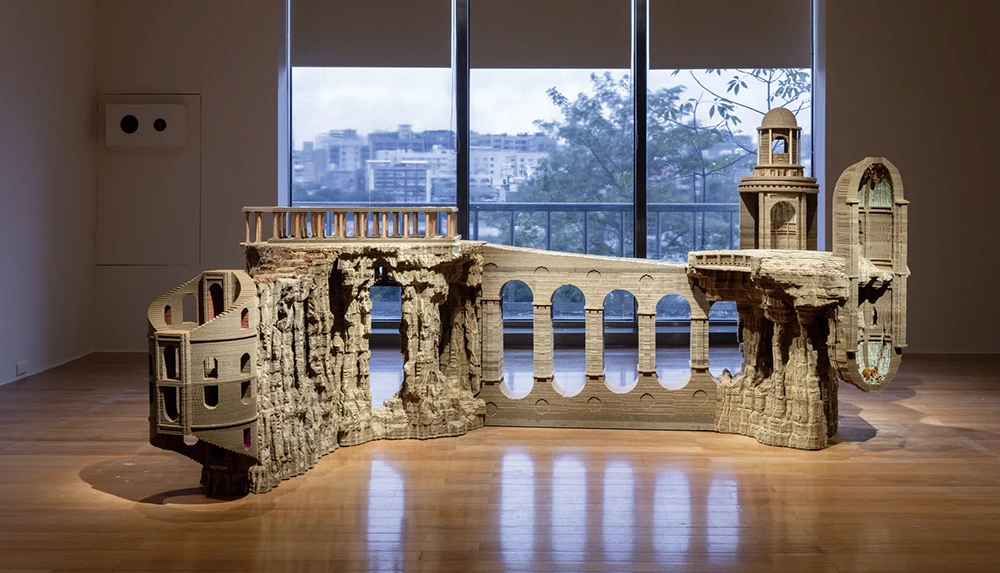 伊娃．喬瑟邦（Eva Jospin），《此處》（<i>Ici</i>），2025，木材、紙板、黃銅、色紙、複合媒材，148×320×206公分，藝術家版權所有。2025台北雙年展現場；呂國瑋攝影。-圖片