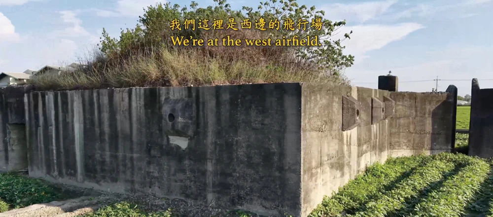 邱子晏，《偽飛行場》，2025，錄像截圖，零式戰鬥機複製品搭配顯示器、影片、碉堡造型之音聲座椅，15分鐘，1200×900×300 公分，120×45×40公分，藝術家版權所有，由 2025台北雙年展委託製作。© 邱子晏-圖片