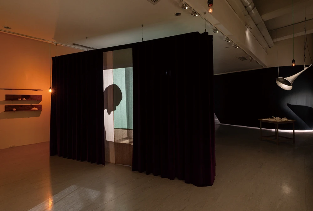 《在無數層疊中無處可尋》（<i>Nowhere in Myriad Layers</i>）， 2025，複合媒材裝置、多頻道錄像，尺寸依空間而定。社團法人臺北市松年福祉會玉蘭莊、SIGMA、就在藝術空間、Ota Fine Arts、James Cohan Gallery 版權所有，協力單位：SIGMA ，Suzuki Takayuki（服裝）。2025台北雙年展現場；呂國瑋攝影。-圖片