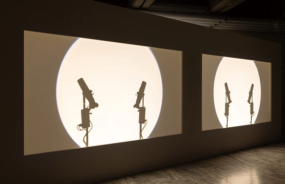 王耀億，《合拍片》，2025，雙頻道錄像、黑白、同步、燈光裝置、投影機、喇叭，20分鐘，1920×1080 (HD)，藝術家版權所有，由 2025台北雙年展委託製作。 2025台北雙年展現場；呂國瑋攝影。-圖片