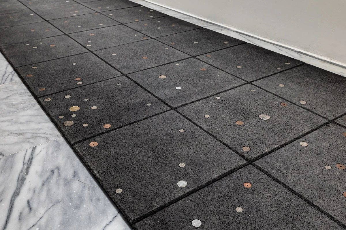 《抗創傷之道》（<i>Anti-Trauma Walk</i>）， 2025， 40 × 40 公分防撞橡膠墊、 法屬印度支那貨幣， 共 126 件，1680 × 120 公分， 69 Art Campus 版權所有。2025 台北雙年展現場；呂國瑋攝影-圖片