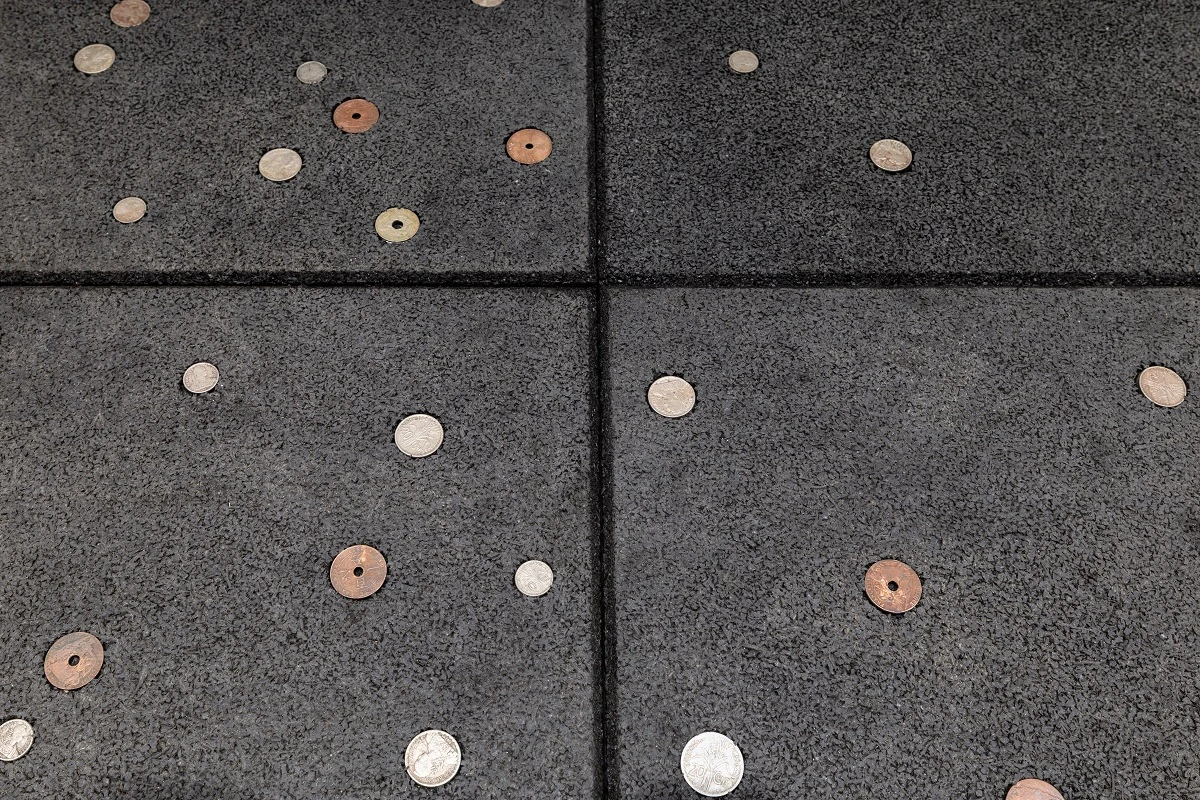 《抗創傷之道》（<i>Anti-Trauma Walk</i>）， 2025， 40 × 40 公分防撞橡膠墊、 法屬印度支那貨幣， 共 126 件，1680 × 120 公分， 69 Art Campus 版權所有。2025 台北雙年展現場；呂國瑋攝影-圖片